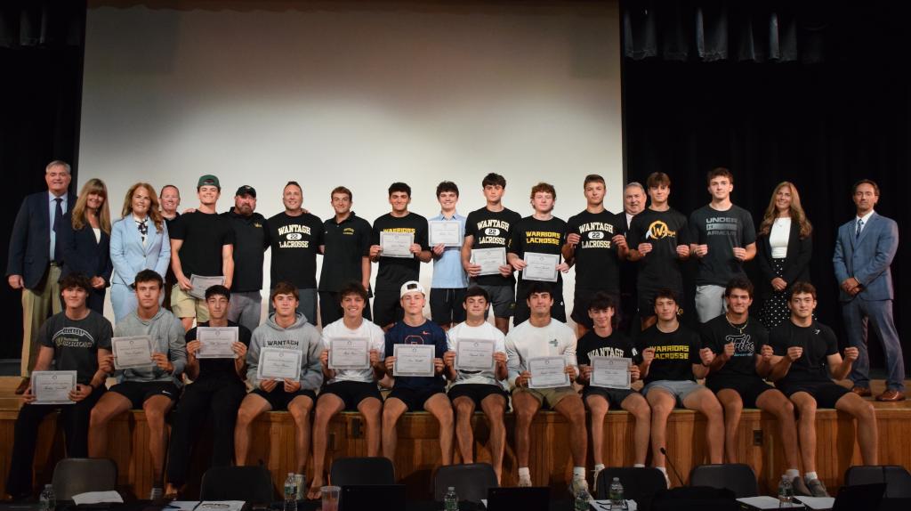 students standing on stage holding certificates